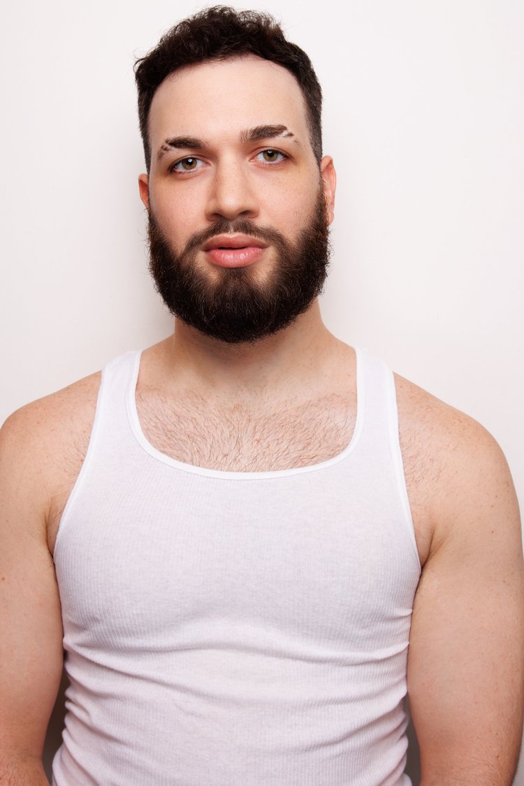 Thomas James in a white tank against a light background